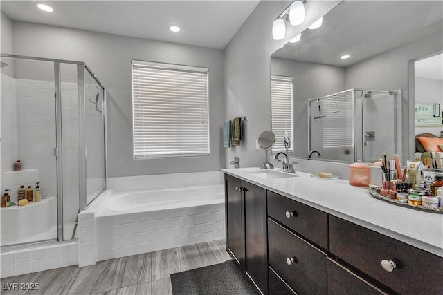 bathroom featuring shower with separate bathtub and vanity