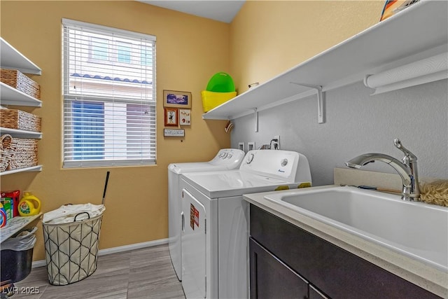 laundry room featuring cabinets, washer and clothes dryer, sink, and a wealth of natural light