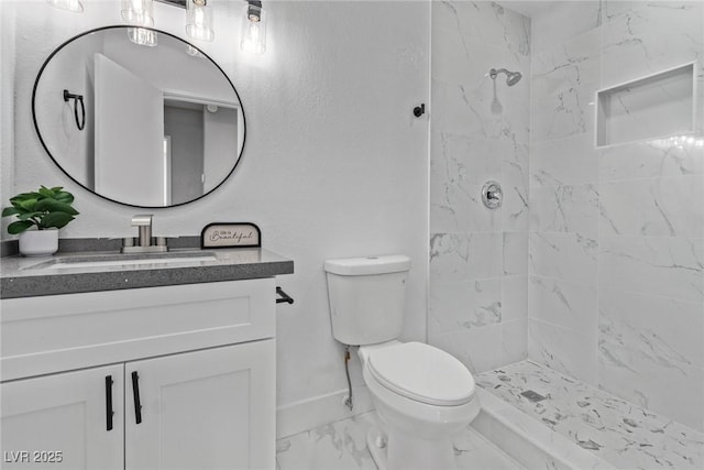 bathroom featuring vanity, a tile shower, and toilet