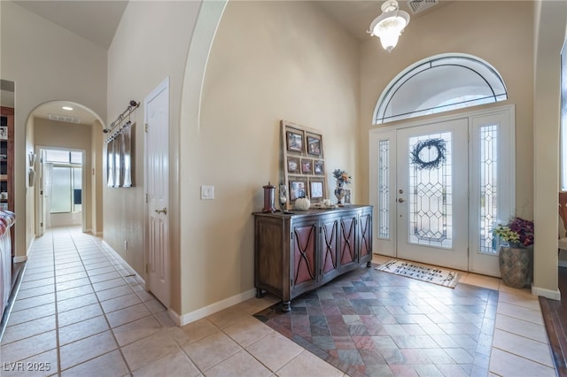 tiled entrance foyer with a high ceiling