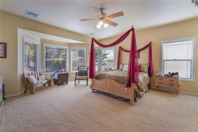 bedroom featuring multiple windows, light colored carpet, and ceiling fan