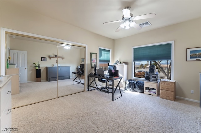 carpeted office space with ceiling fan