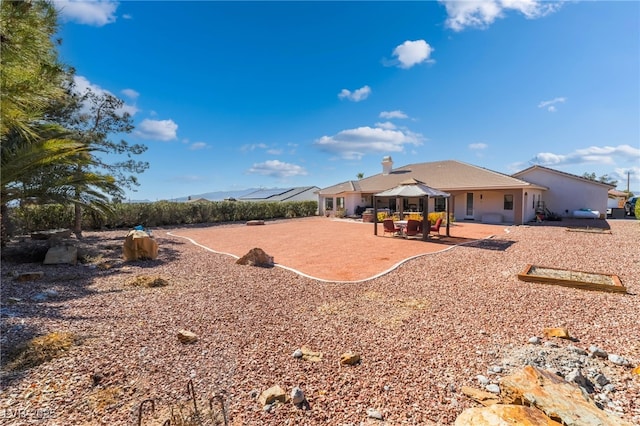 rear view of property featuring a gazebo and a patio