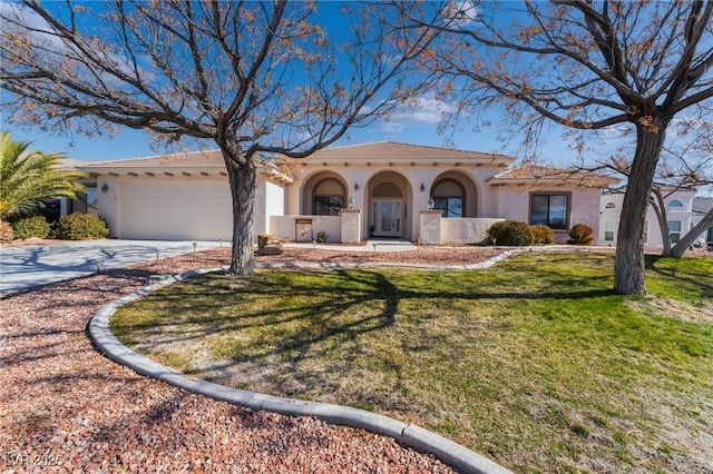 mediterranean / spanish home featuring a garage and a front yard