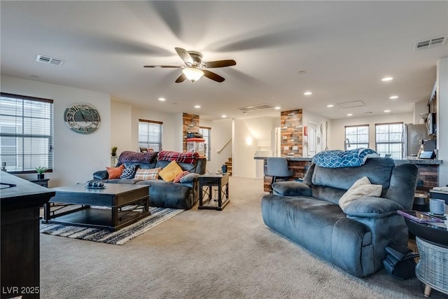 living room featuring ceiling fan, light colored carpet, and a healthy amount of sunlight