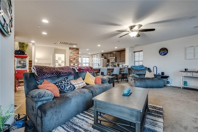 carpeted living room featuring a wealth of natural light and ceiling fan