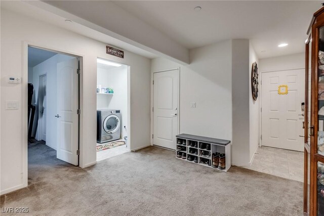 clothes washing area with washer / clothes dryer and light colored carpet