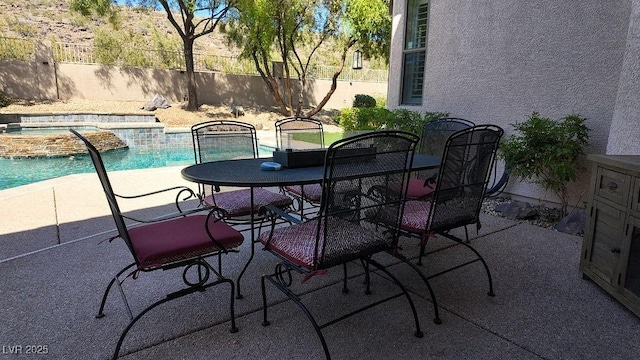 view of patio / terrace with outdoor dining space, fence, and a fenced in pool