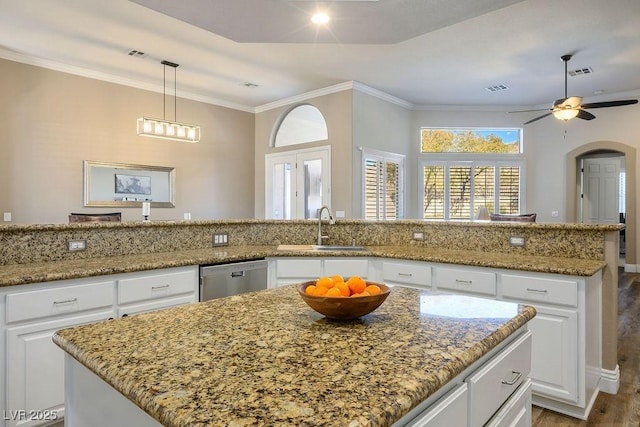 kitchen with a sink, white cabinetry, visible vents, stainless steel dishwasher, and pendant lighting