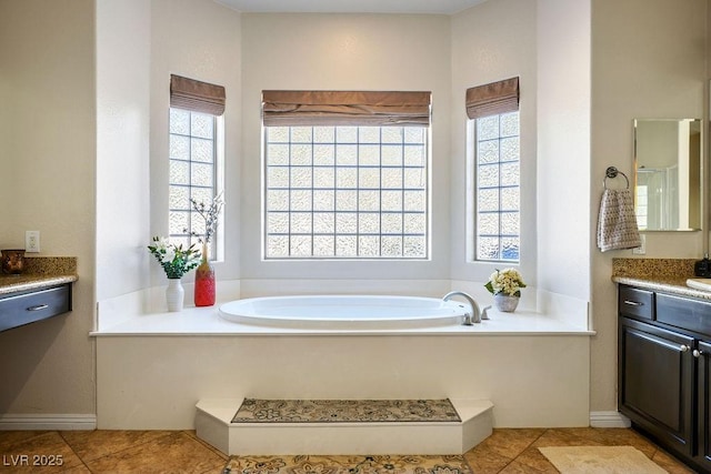 full bath with tile patterned flooring, vanity, baseboards, and a bath