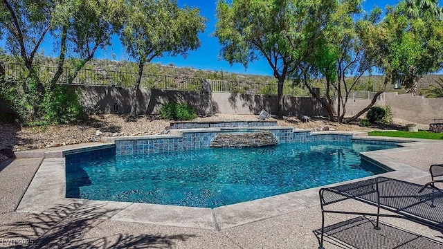 view of pool with a patio area, a fenced backyard, and a pool with connected hot tub