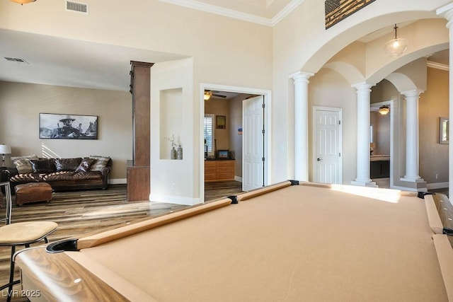 rec room with ornate columns, visible vents, arched walkways, and ceiling fan