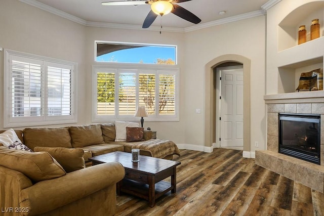 2012 Poetry Ave, Henderson, NV 89052 - living area with ceiling fan, baseboards, a tiled fireplace, ornamental molding, and dark wood-style flooring