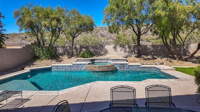 view of swimming pool featuring a pool with connected hot tub, a fenced backyard, and a patio