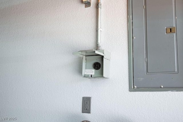 details featuring electric panel and stucco siding