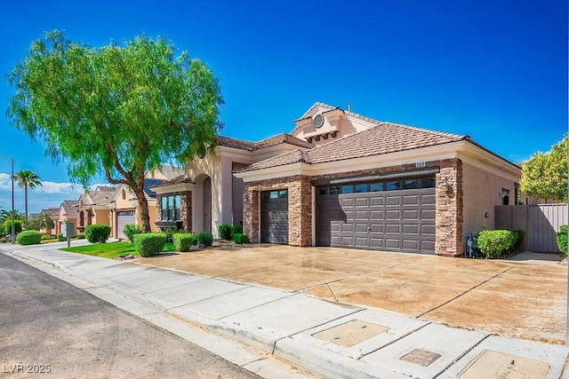 mediterranean / spanish-style home featuring a garage, stucco siding, concrete driveway, and a tiled roof