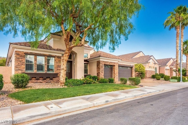 mediterranean / spanish house featuring stone siding, a front lawn, an attached garage, and driveway