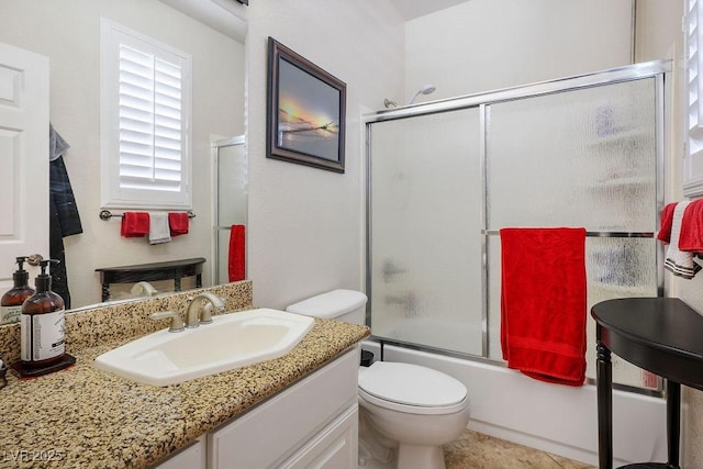 full bathroom featuring toilet, shower / bath combination with glass door, vanity, and tile patterned floors