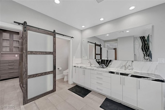 bathroom with tile patterned floors, vanity, toilet, and backsplash