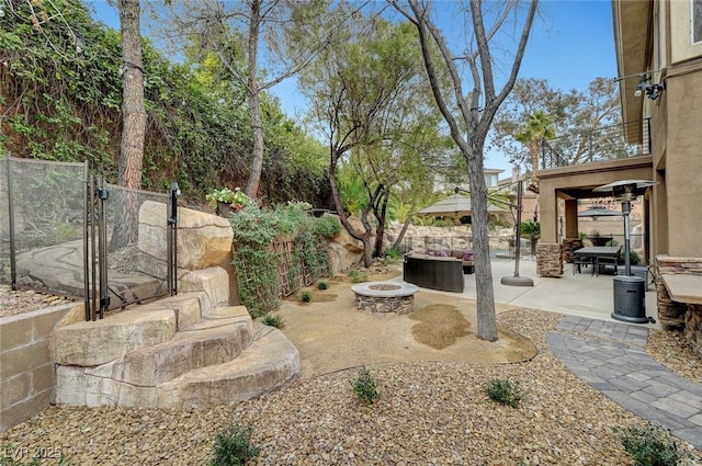 view of yard featuring an outdoor fire pit and a patio