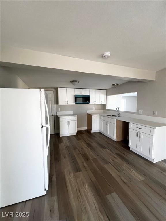 kitchen featuring dark hardwood / wood-style floors, sink, white fridge, and white cabinets