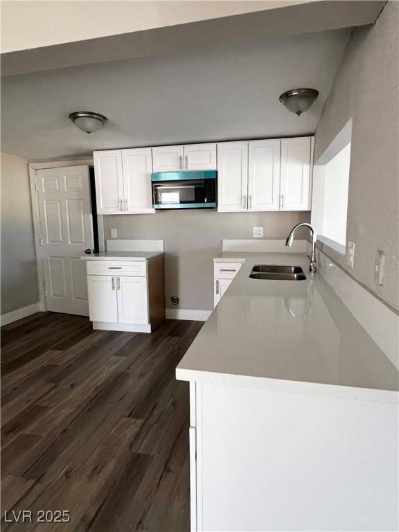 kitchen with white cabinetry, sink, and dark wood-type flooring