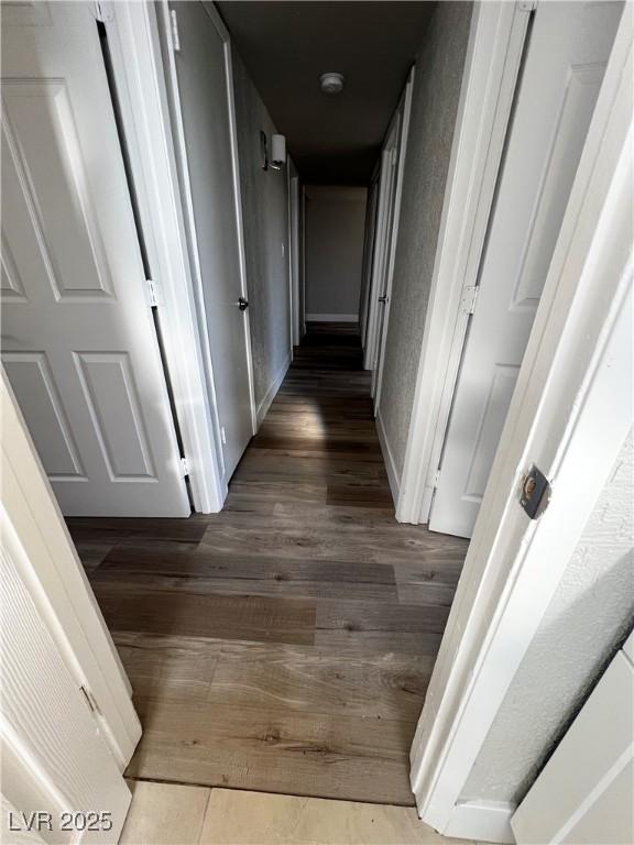 corridor with dark hardwood / wood-style flooring