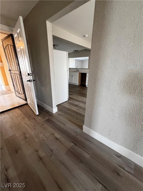 unfurnished room featuring dark wood-type flooring and sink