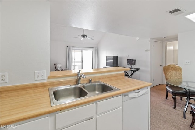 kitchen with white cabinetry, sink, light colored carpet, white dishwasher, and kitchen peninsula