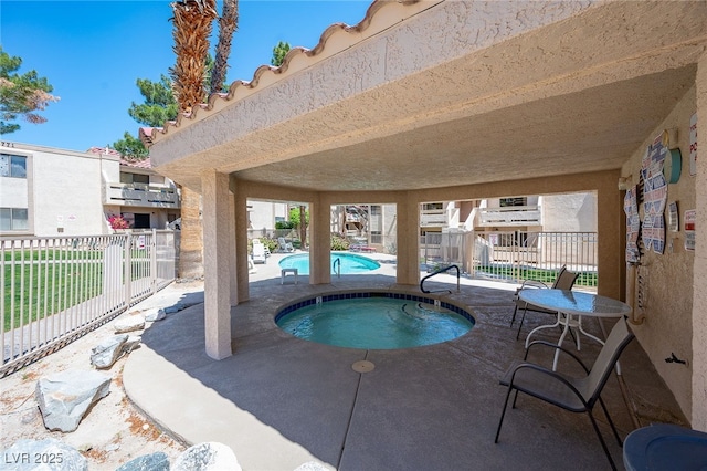 view of swimming pool featuring a patio area and a hot tub