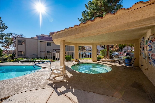 view of swimming pool featuring a community hot tub and a patio area