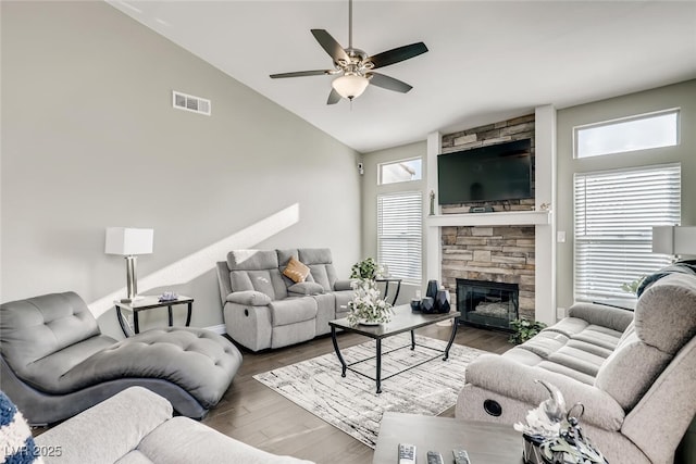 living room featuring lofted ceiling, a fireplace, dark hardwood / wood-style floors, and ceiling fan