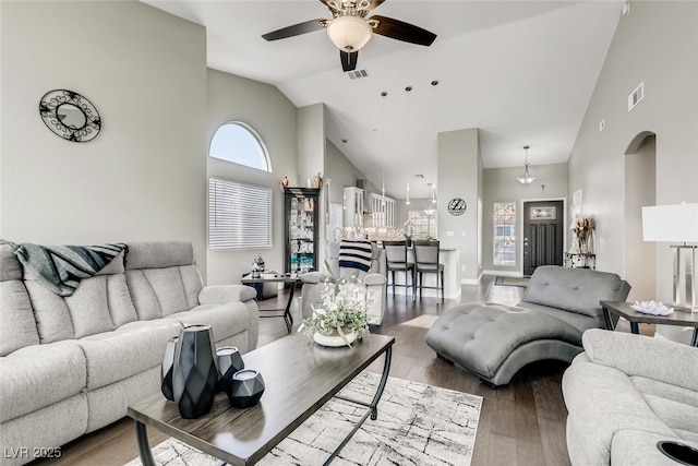 living room with wood-type flooring, ceiling fan, and high vaulted ceiling