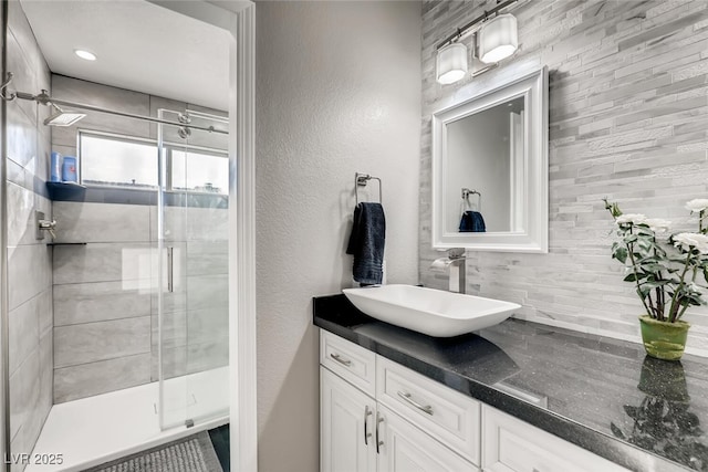 bathroom with a shower with door and vanity