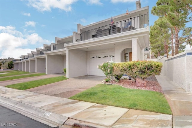 view of front of home with a garage, a balcony, and a front yard