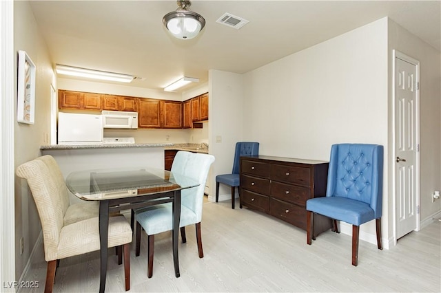 dining space with light hardwood / wood-style floors