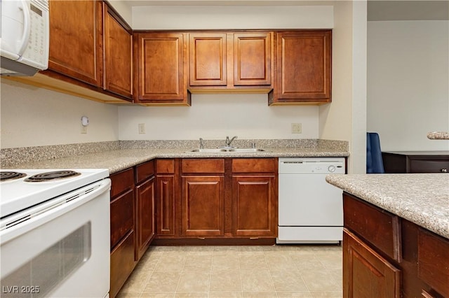 kitchen featuring sink, white appliances, and light tile patterned floors