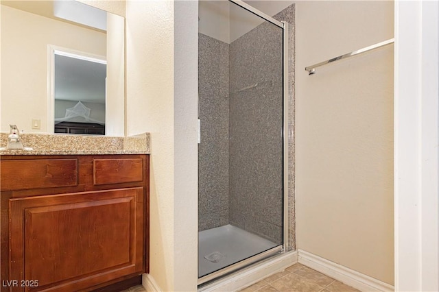 bathroom featuring tile patterned flooring, vanity, and walk in shower