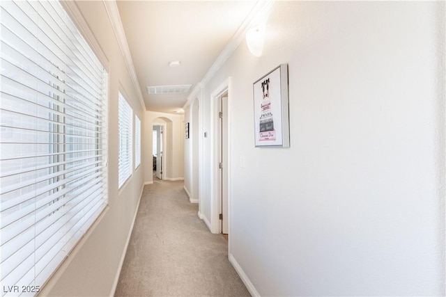 hall with crown molding and light colored carpet