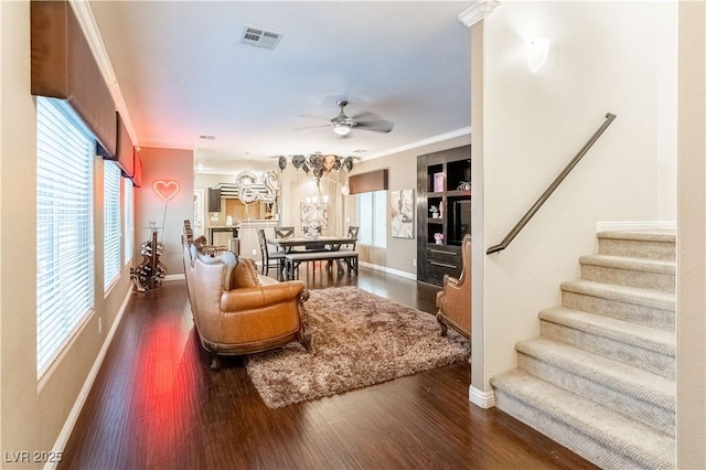 living room featuring ceiling fan, ornamental molding, and dark hardwood / wood-style flooring