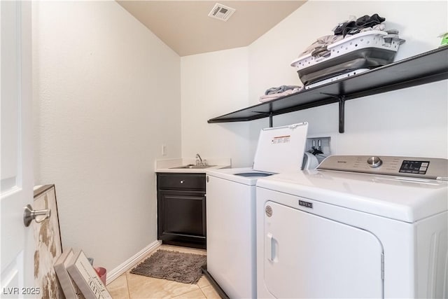 laundry room featuring cabinets, washer and dryer, sink, and light tile patterned floors