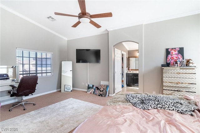 carpeted bedroom featuring crown molding, vaulted ceiling, ceiling fan, and ensuite bath