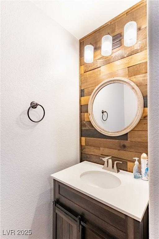 bathroom with vanity and wooden walls