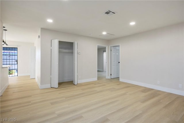 unfurnished bedroom featuring light hardwood / wood-style flooring and a closet