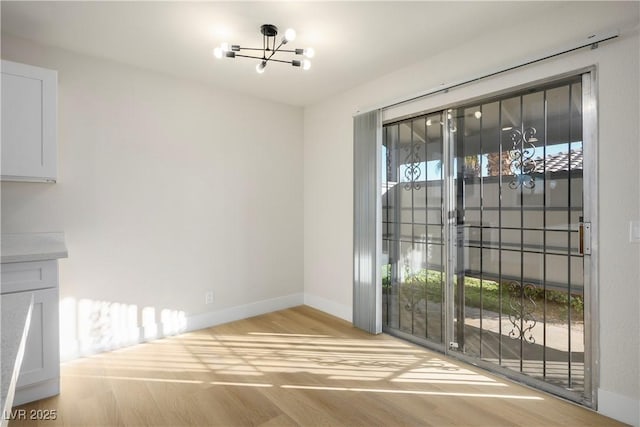 unfurnished dining area with light hardwood / wood-style floors and a chandelier