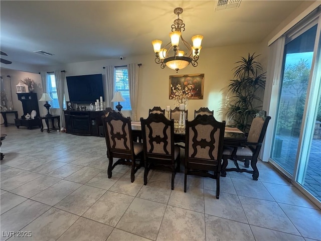 dining area with light tile patterned floors and a chandelier