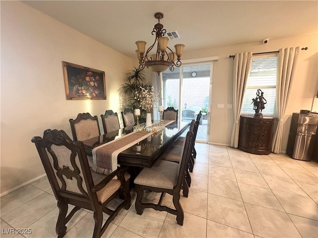 dining area featuring light tile patterned flooring, plenty of natural light, and a notable chandelier