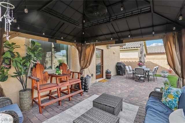 view of patio / terrace featuring grilling area, fence, outdoor dining area, a gazebo, and an outdoor living space