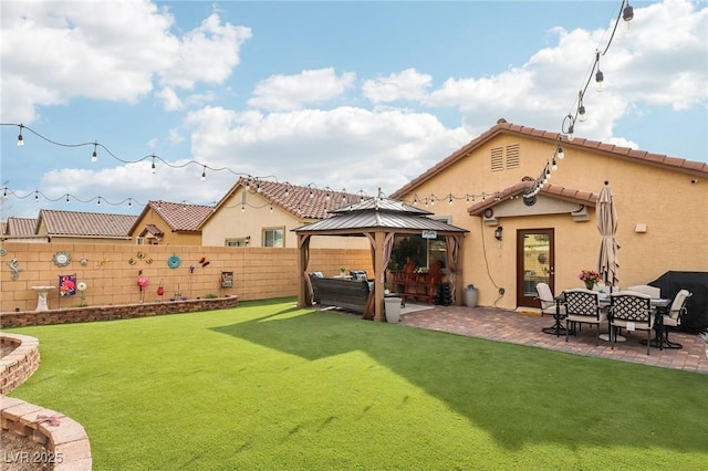 rear view of house with a patio, a fenced backyard, a gazebo, a lawn, and stucco siding