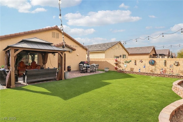 back of property featuring a gazebo, a fenced backyard, a lawn, and stucco siding